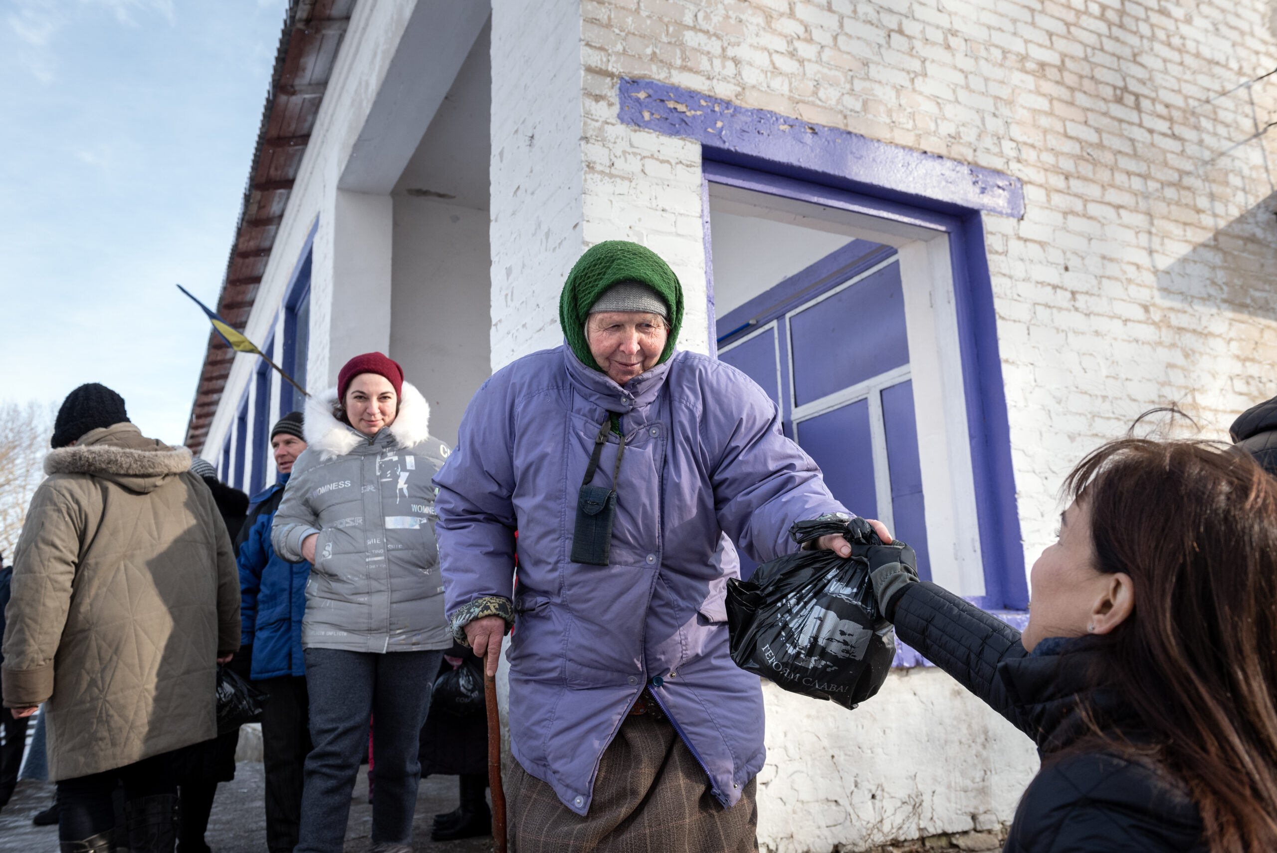A woman reaches for a bag of food that Mike Domke, an IMB missionary, and Cade and Ginny Wheeler of Send Relief, distributed food packets to people living near Kozelets, Ukraine. Send Relief partners with a local church to provide food packets to those in need in the community. IMB Photo
