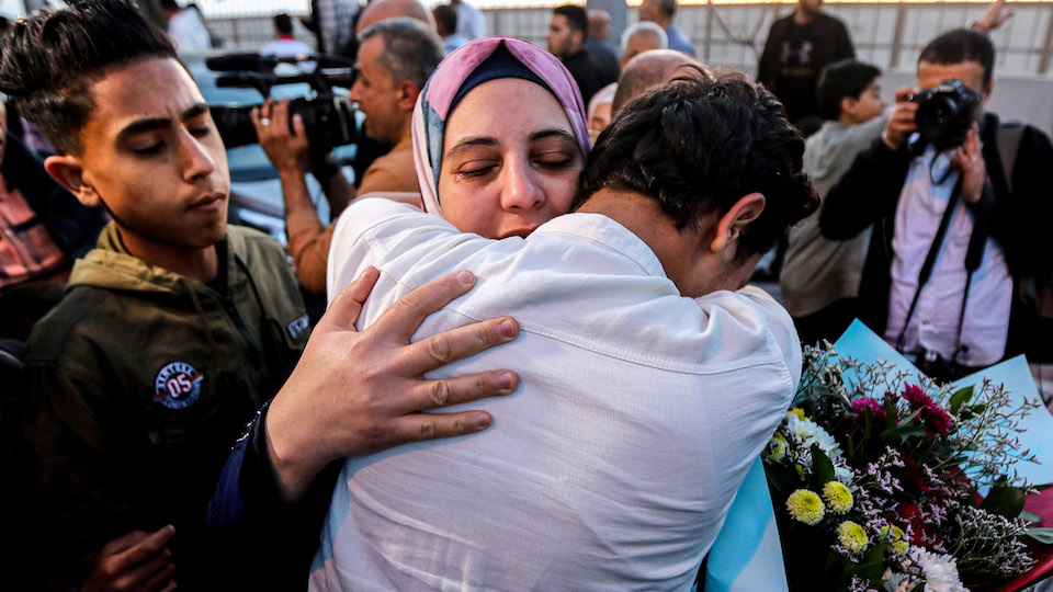 GAZA, PALESTINE - 2023/04/28: Palestinians greet their relatives at the gate of the Rafah crossing in the southern Gaza Strip, who were evacuated from Sudan due to the conflict between rival military forces. (Photo by Yousef Masoud/SOPA Images/LightRocket via Getty Images)